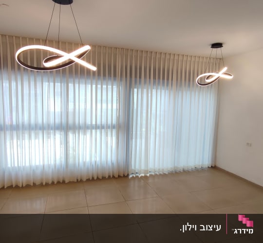 וילון לבן שקוף תלוי על חלון גדול